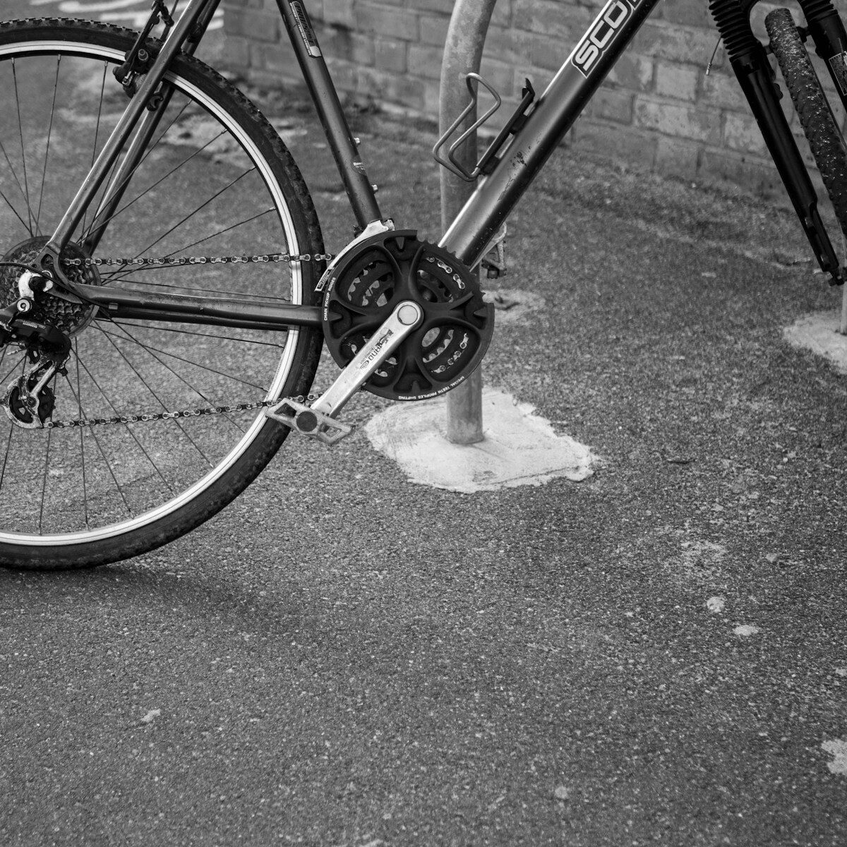 A black and white close-up of a bicycle chain.